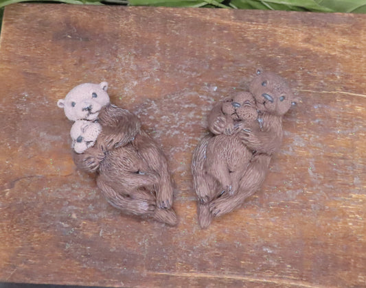 Adorable handmade mother otter holding baby goat milk soap